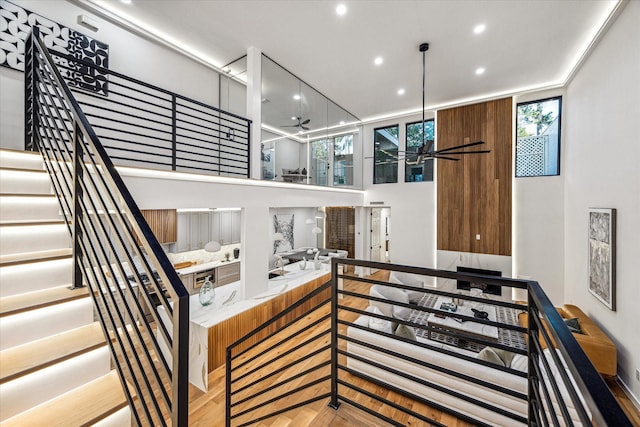 stairway featuring ceiling fan, wood finished floors, and recessed lighting