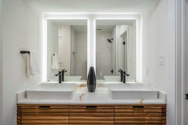 full bath with double vanity, a shower, and a sink