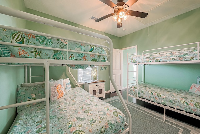 bedroom with attic access, visible vents, and ceiling fan