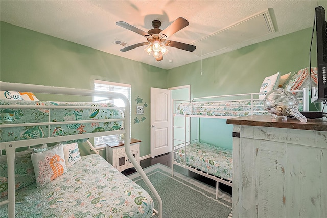 bedroom featuring attic access, visible vents, and ceiling fan