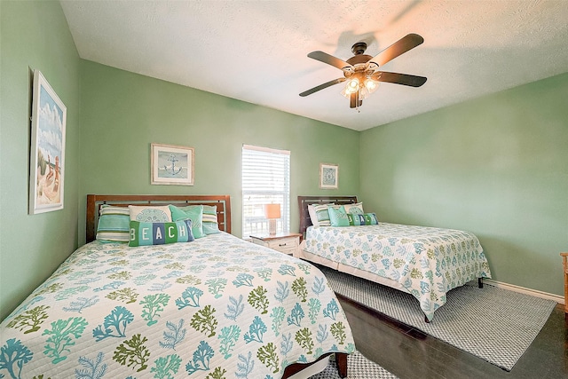 bedroom featuring a textured ceiling, ceiling fan, carpet floors, and baseboards