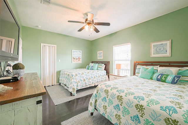 bedroom featuring a textured ceiling, ceiling fan, wood finished floors, and visible vents