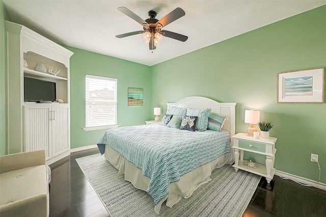 bedroom featuring wood finished floors, a ceiling fan, and baseboards