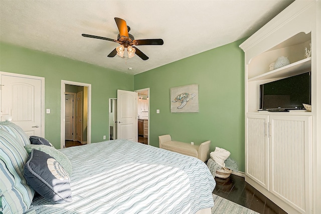 bedroom with ceiling fan, baseboards, dark wood finished floors, and a textured ceiling