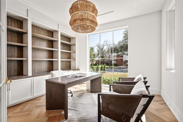 home office with a chandelier, a wealth of natural light, and baseboards