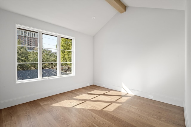 empty room with vaulted ceiling with beams, baseboards, and light wood-style floors