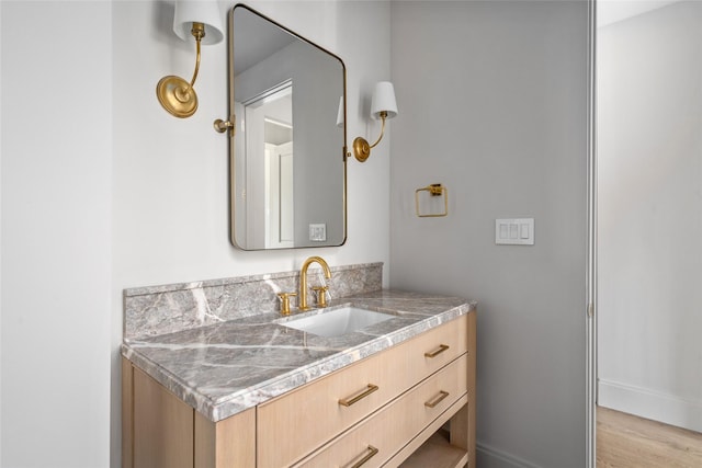 bathroom with baseboards, wood finished floors, and vanity