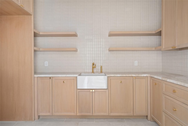 kitchen with light brown cabinets, a sink, and open shelves