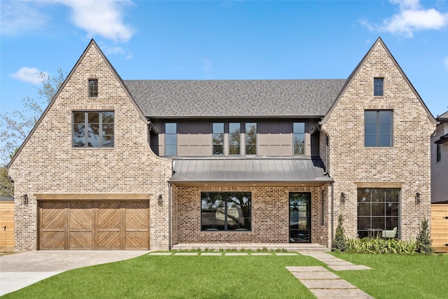 view of front of home featuring a standing seam roof, driveway, brick siding, and a front lawn