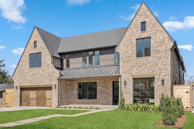 view of front of home with brick siding, board and batten siding, a front yard, a standing seam roof, and a garage