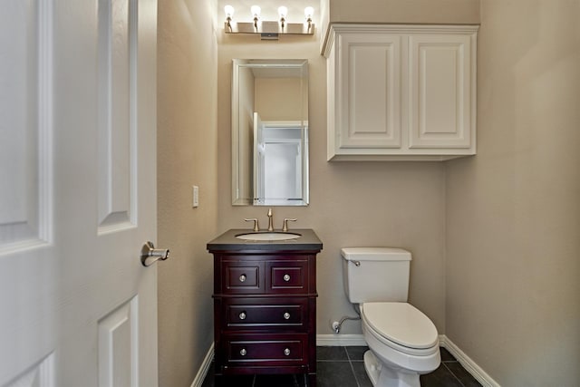 bathroom featuring toilet, vanity, baseboards, and tile patterned floors