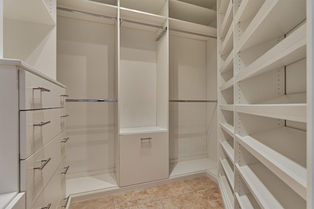 walk in closet with light tile patterned floors