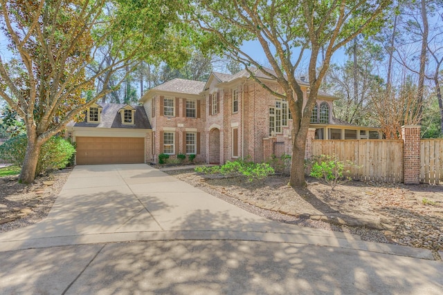 view of front of property with a garage, concrete driveway, brick siding, and fence