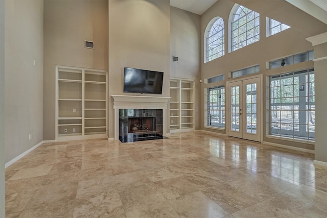 unfurnished living room featuring french doors, a fireplace, visible vents, and baseboards