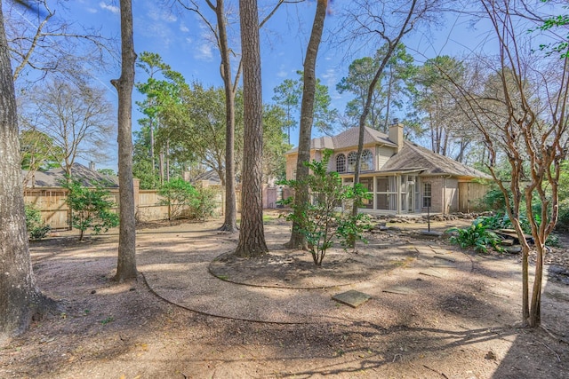 view of yard featuring a sunroom and fence