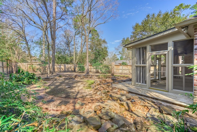 view of yard with a sunroom and a fenced backyard