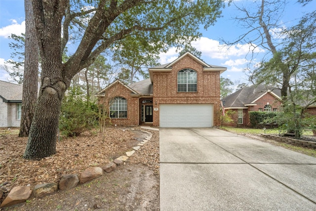 traditional home with a garage, brick siding, and driveway