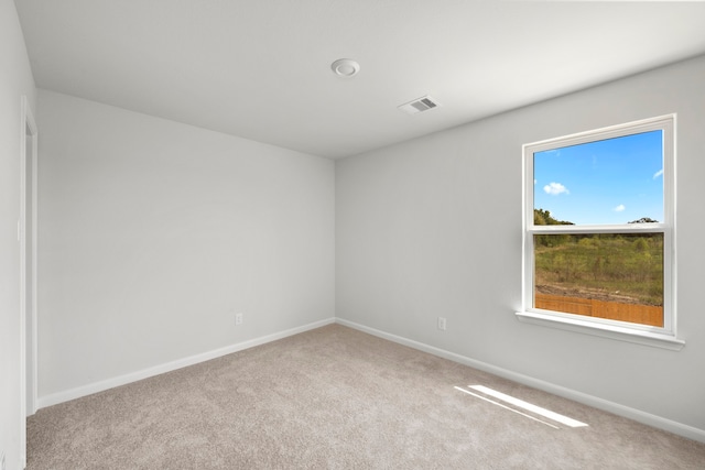 unfurnished room featuring carpet, visible vents, and baseboards