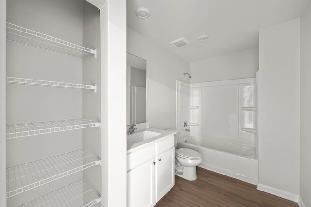 full bathroom featuring toilet, wood finished floors, visible vents, vanity, and tub / shower combination