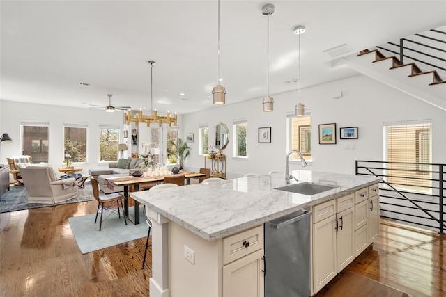 kitchen featuring dark wood-type flooring, open floor plan, dishwasher, and a sink