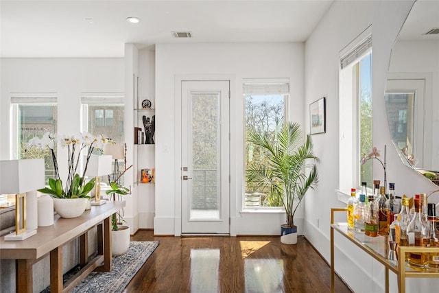 doorway with baseboards, visible vents, wood finished floors, and recessed lighting