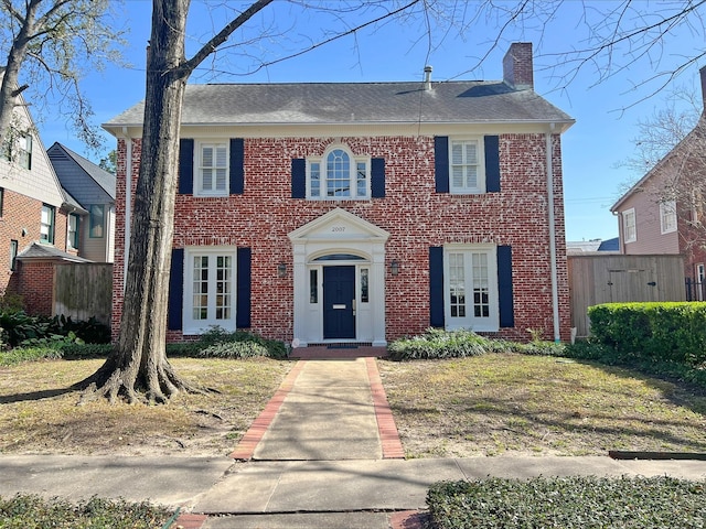 view of front of property with brick siding and a chimney