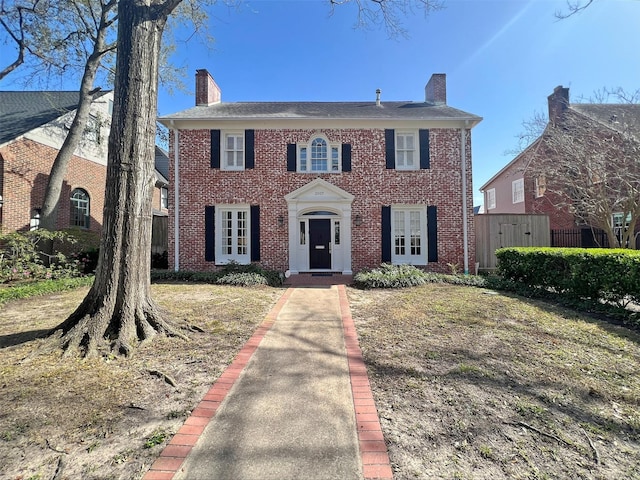 view of front of house with brick siding and a chimney