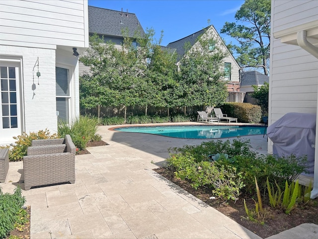 view of pool featuring a patio, fence, a fenced in pool, and a grill