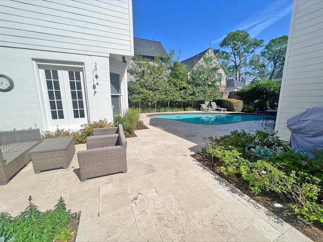 view of swimming pool featuring a fenced in pool, fence, a grill, and a patio area