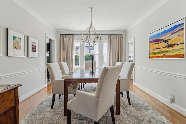 dining area featuring baseboards, crown molding, and light wood finished floors