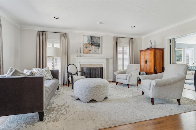 living area with recessed lighting, wood finished floors, a fireplace, and ornamental molding