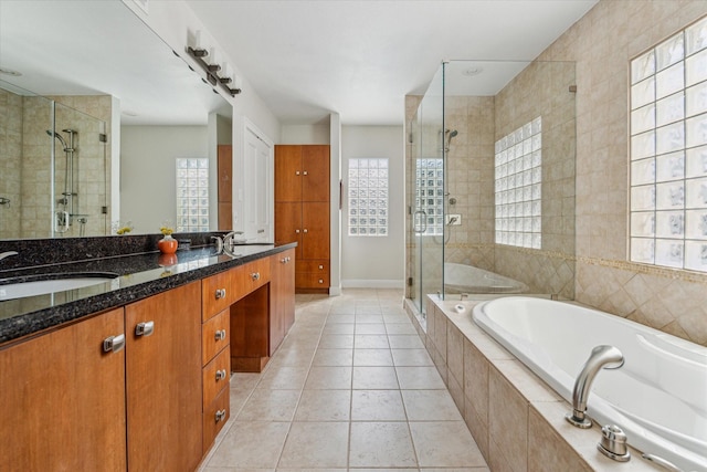 bathroom with a shower stall, a garden tub, double vanity, and tile patterned floors