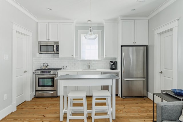 kitchen with backsplash, light wood-style floors, appliances with stainless steel finishes, and a sink