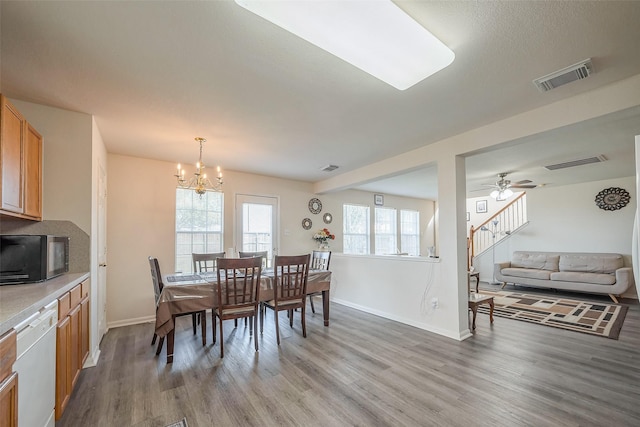 dining area featuring light wood-style floors, visible vents, baseboards, and ceiling fan with notable chandelier