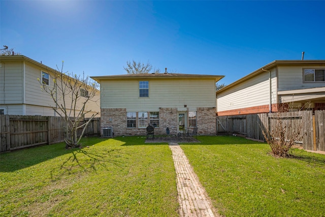 back of house with brick siding, a yard, a fenced backyard, and central AC unit