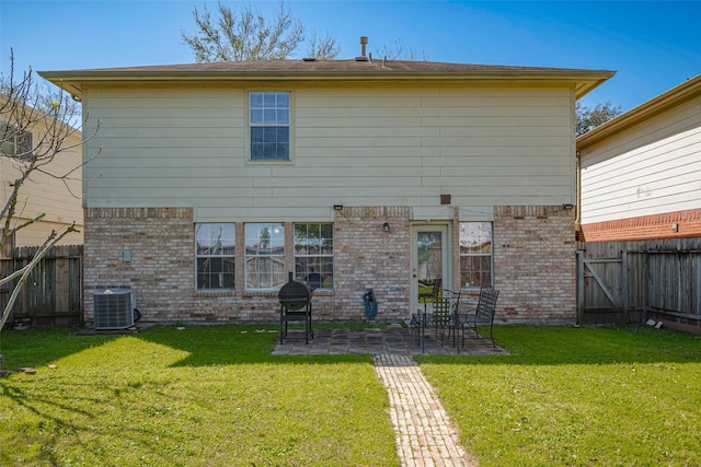 rear view of house featuring brick siding, a yard, a patio, cooling unit, and a fenced backyard