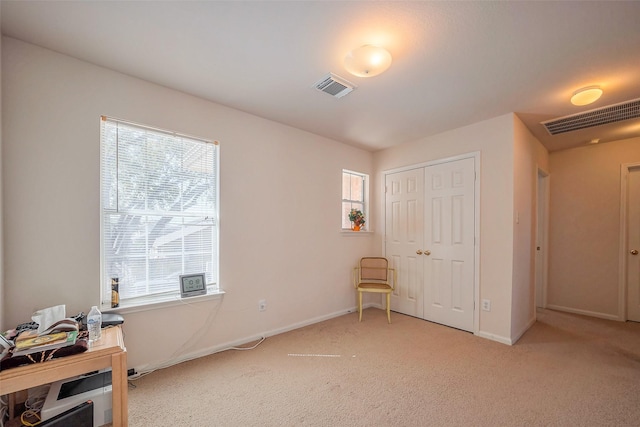 interior space featuring light carpet, multiple windows, and visible vents