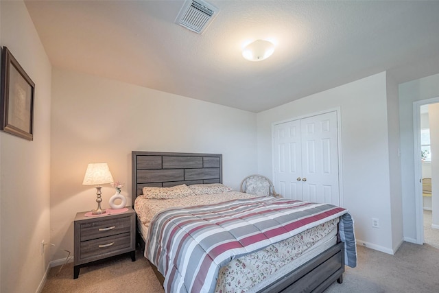 bedroom featuring light carpet, a closet, visible vents, and baseboards