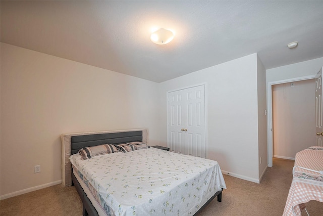 bedroom featuring light carpet and baseboards