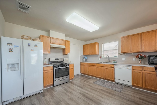 kitchen with white appliances, visible vents, light countertops, and a sink