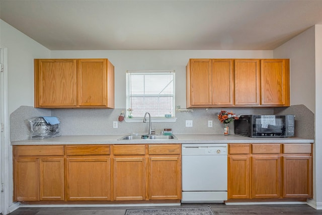 kitchen featuring black microwave, a sink, light countertops, backsplash, and dishwasher