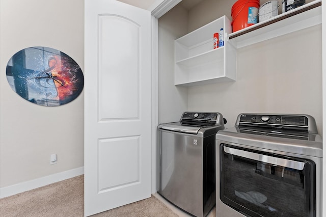 washroom with light carpet, laundry area, washer and clothes dryer, and baseboards