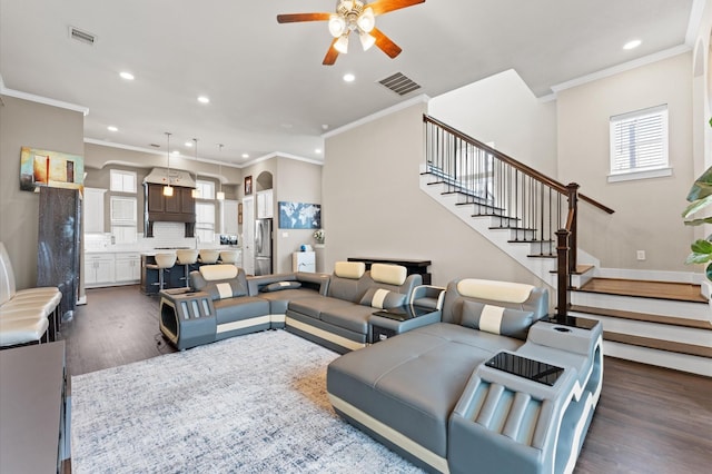 living area with ceiling fan, stairs, visible vents, and dark wood finished floors