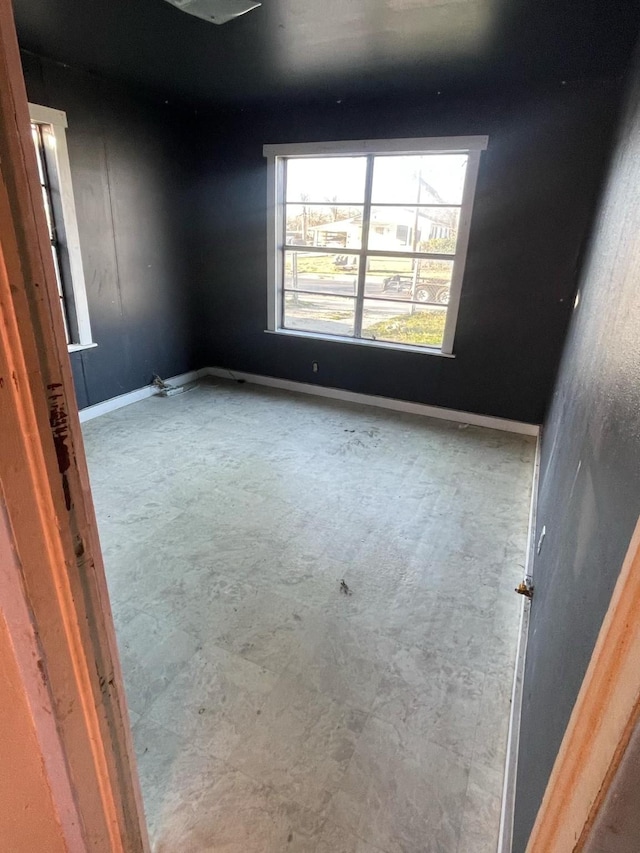 spare room with baseboards