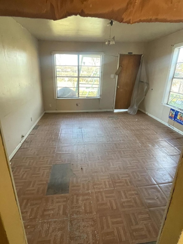 unfurnished room with baseboards