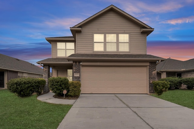 traditional-style house with a garage, brick siding, a shingled roof, driveway, and a front yard