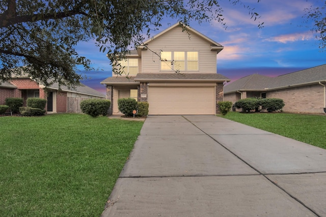 traditional-style home with driveway, a shingled roof, an attached garage, a front yard, and brick siding