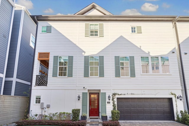 view of property featuring decorative driveway and an attached garage