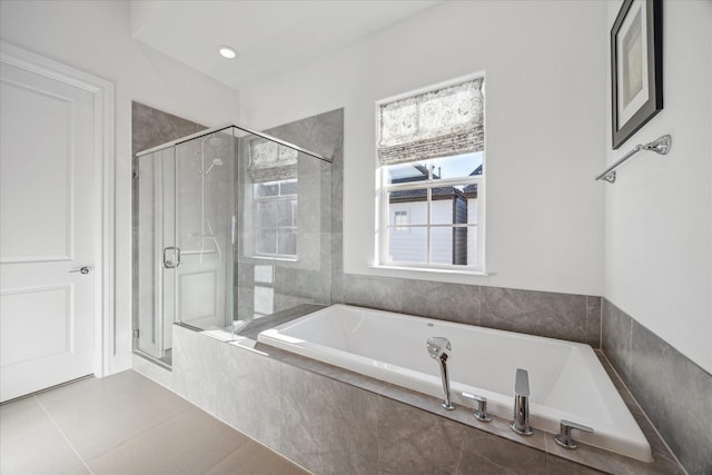 bathroom with tile patterned flooring, a shower stall, and a bath