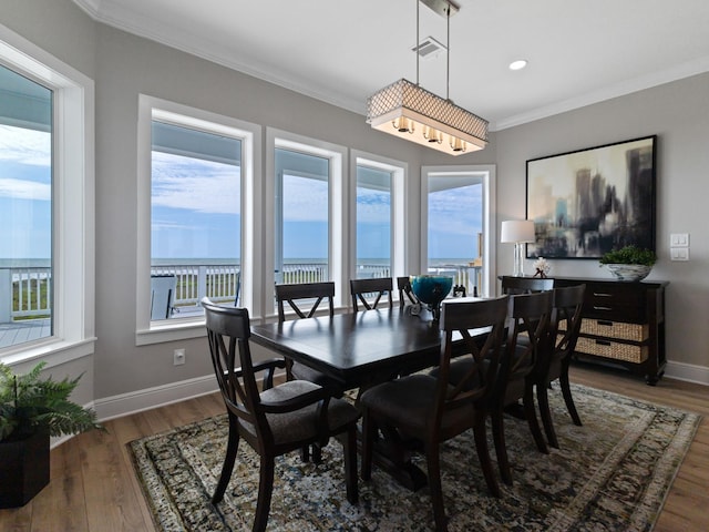 dining room featuring ornamental molding, wood finished floors, a wealth of natural light, and baseboards